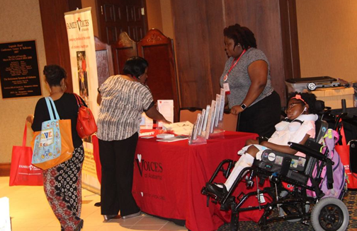 A conference attendee visits a vendor table