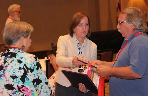 ADRS Commissioner Jane Elizabeth Burdeshaw provides a copy of the ADRS annual report to a conference attendee
